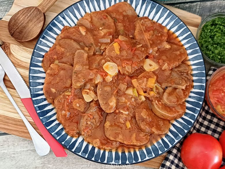 מנת צלי בקר מוגשת על צלחת עם הרבה רוטב סמיך.